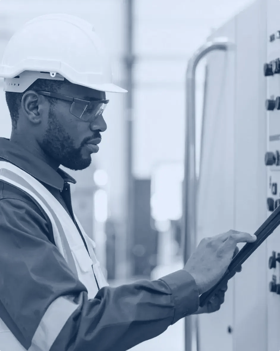 un technicien de maintenance effectue des réparations avec sa tablette en main