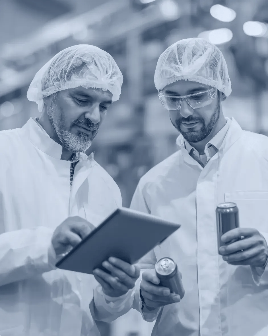 deux hommes dans une usine consultent une tablette