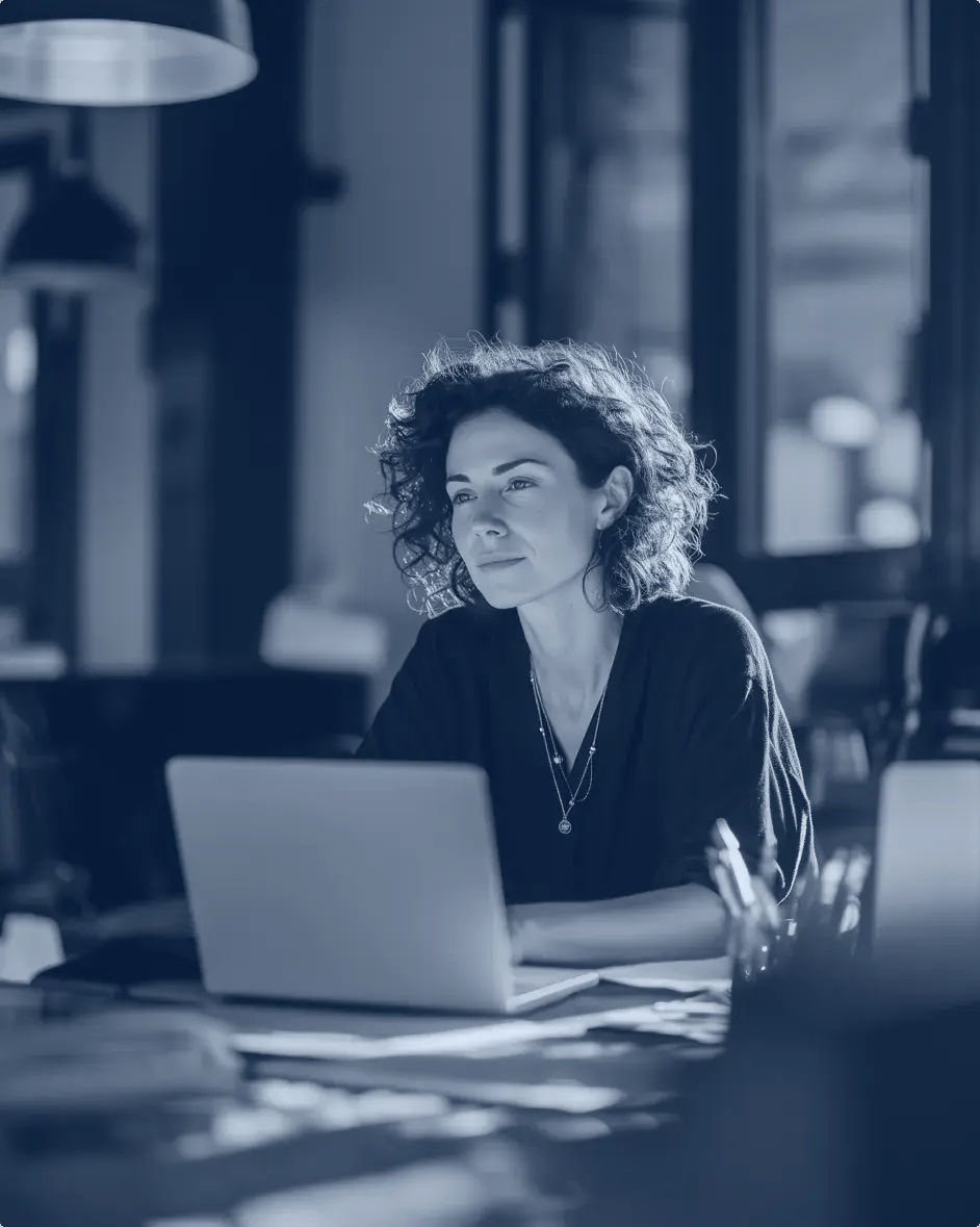 une femme assise à un bureau devant un ordinateur portable