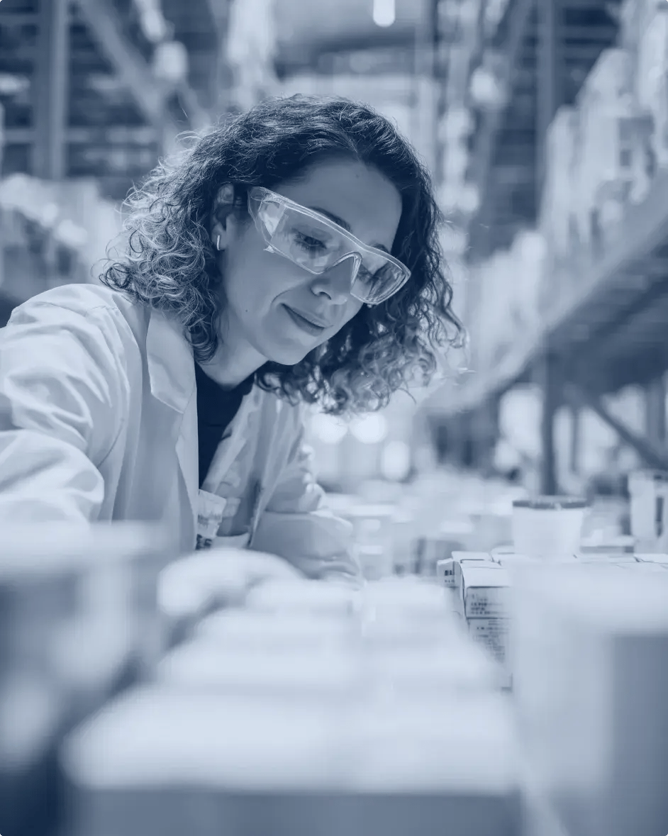 une femme devant une ligne de production dans une usine de chimie, qui se penche sur les produits