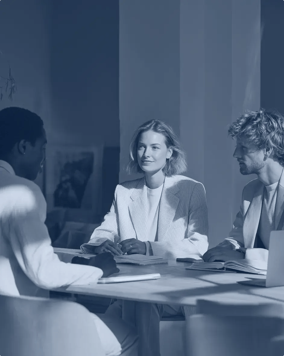 trois personnes assises autour d'une table